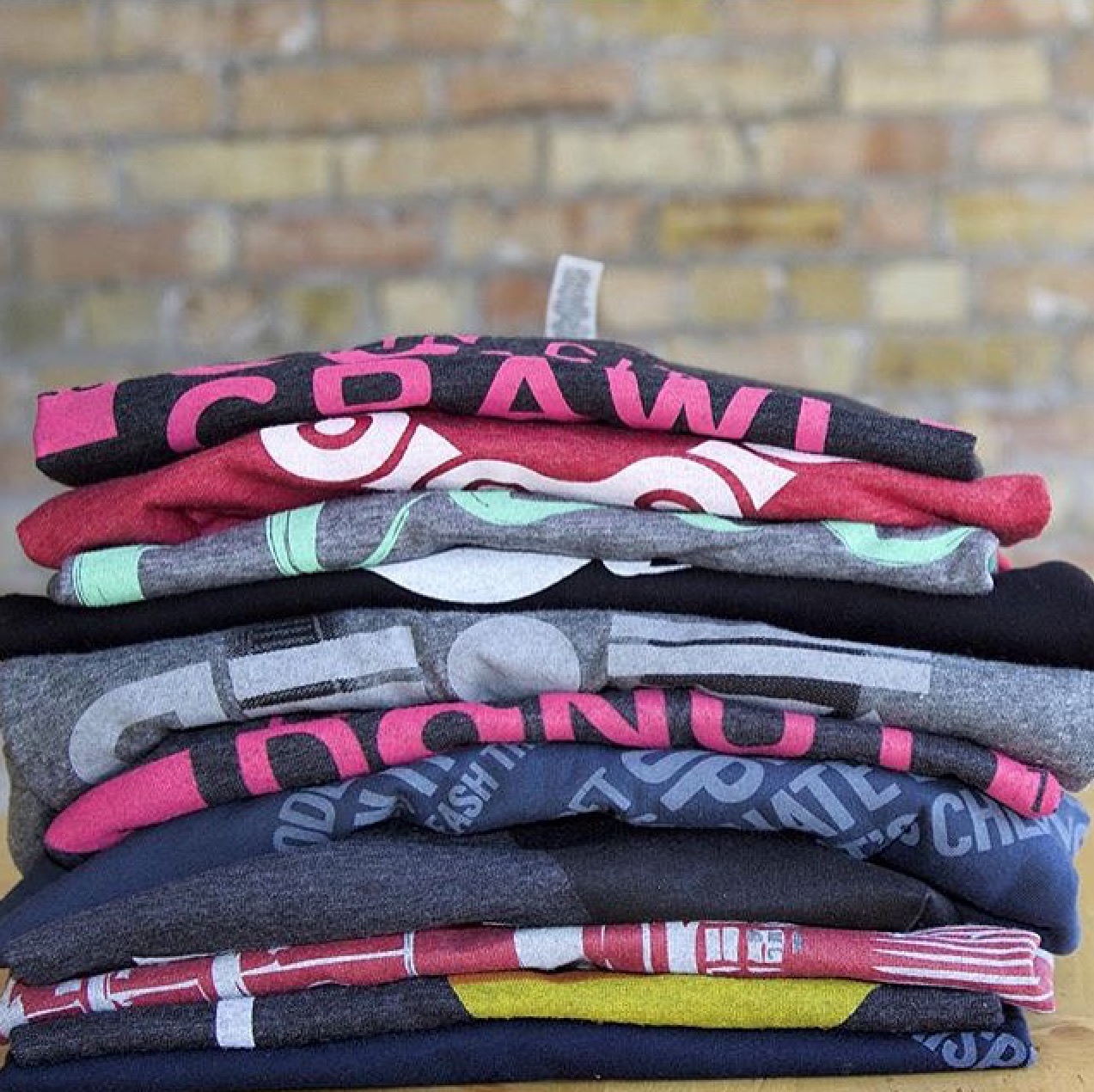 Stacked t-shirts showing branded merchandise