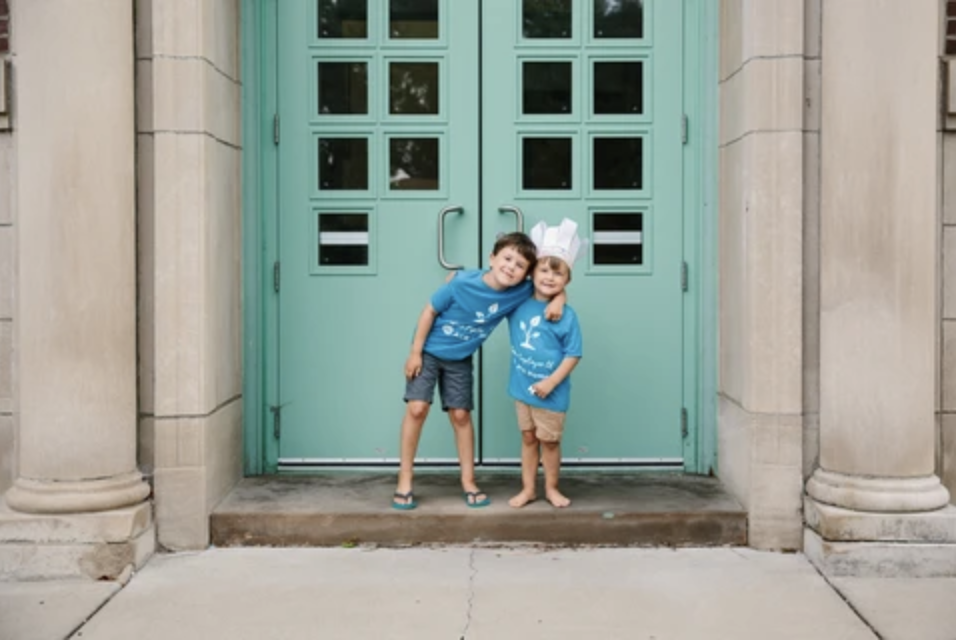 Two kids in front of a door wearing ACR Homes shirts by Foxtrot Custom